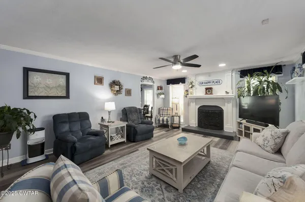 a living room with furniture a flat screen tv and a floor to ceiling window