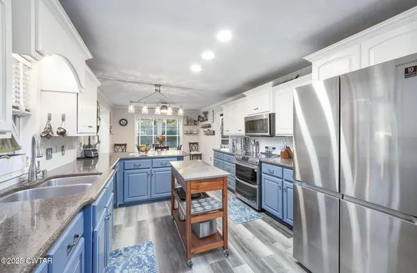 a kitchen with stainless steel appliances granite countertop a stove sink and cabinets