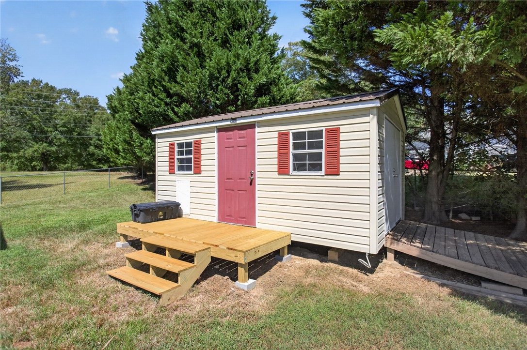 564 Fairfield Road Walhalla, SC 29691 - Photo 36 of 50 A detached storage shed with a wooden entryway platform sits on the grassy lawn.