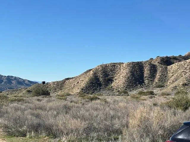 a view of a large mountain with mountains in the background