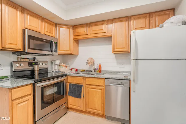 a kitchen with white cabinets sink and stainless steel appliances