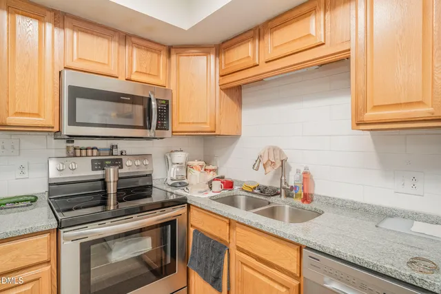 a kitchen with stainless steel appliances granite countertop a sink stove and microwave