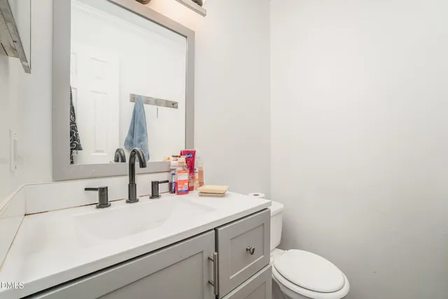 a bathroom with a sink vanity mirror and toilet