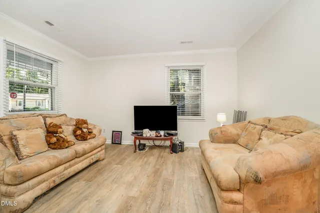 a spacious bedroom with a bed and wooden floor
