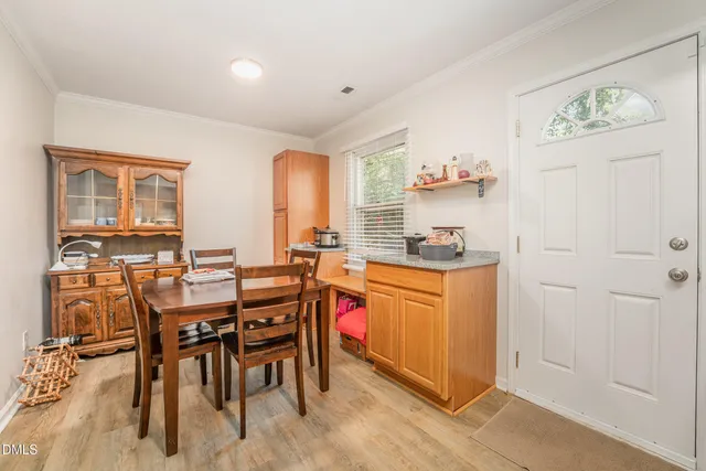 a kitchen with stainless steel appliances granite countertop a table and chairs in it