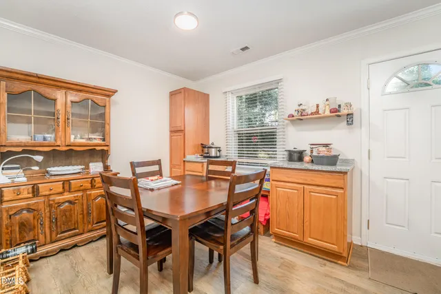 a dining hall with stainless steel appliances granite countertop a dining table and chairs with wooden floor