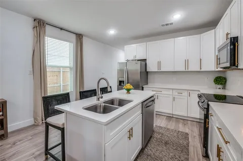a kitchen with a stove a sink and a microwave