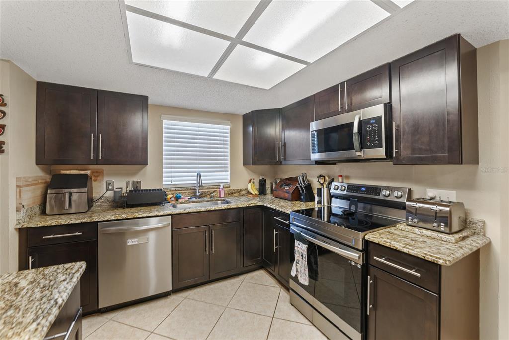 8715 Huntsman Lane Port Richey, FL 34668 - Photo 14 of 54 a kitchen with a sink stove and microwave
