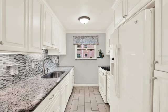 a white stove top oven sitting inside of a kitchen