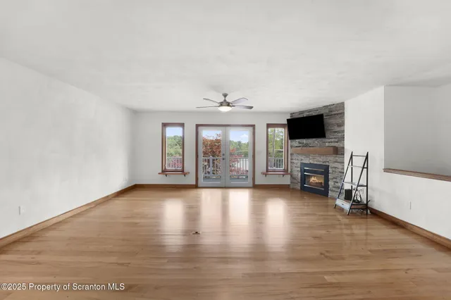 a view of a livingroom with furniture a ceiling fan and wooden floor