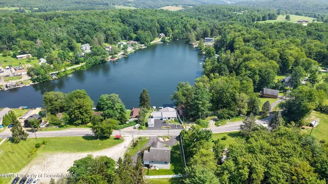 an aerial view of a house with a yard and lake view