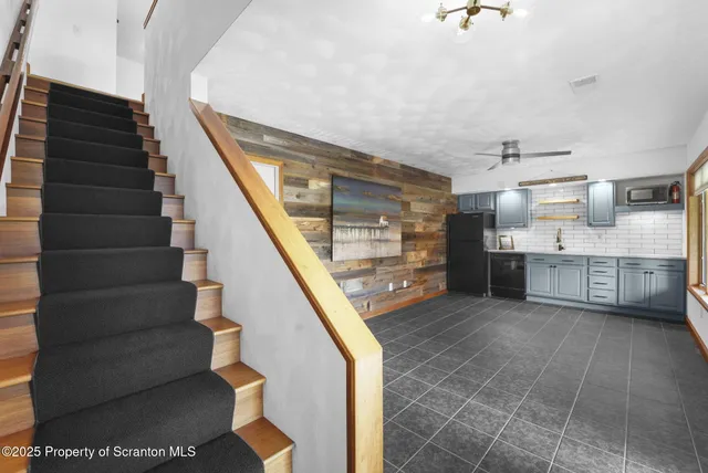 a view of a livingroom with an entryway and a ceiling fan
