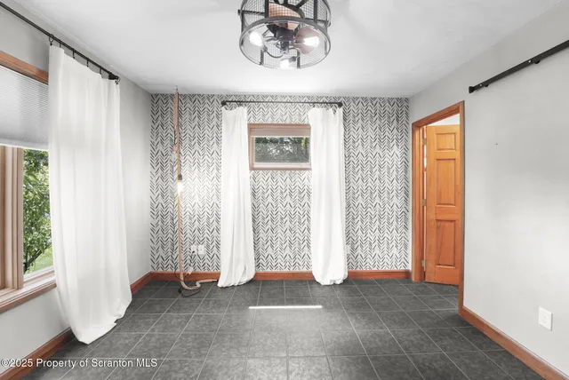 a view of a livingroom with wooden floor and a ceiling fan