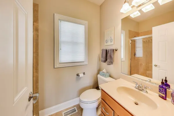 a spacious bedroom with a bed a chandelier and fan