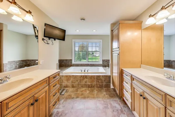 a bedroom with a bed a bookshelf and a large window