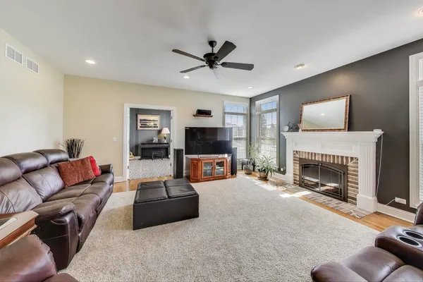 a living room with furniture a flat screen tv and a fireplace