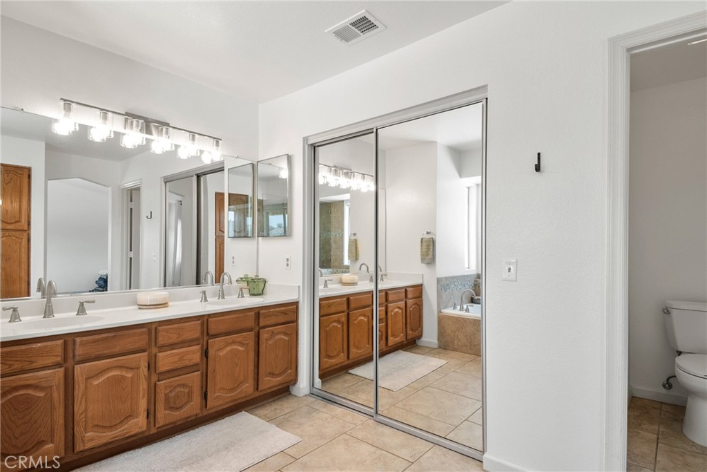 9376 Ruby Red Court Riverside, CA 92508 - Photo 27 of 54 a spacious bathroom with a double vanity sink a large mirror and a bathtub