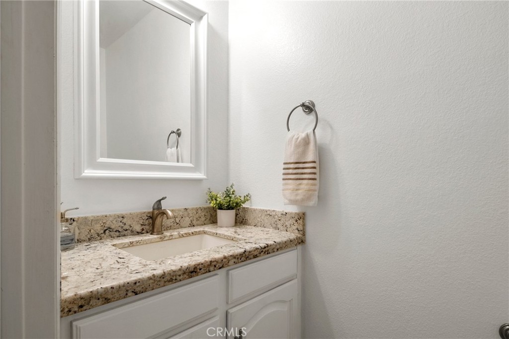 9376 Ruby Red Court Riverside, CA 92508 - Photo 31 of 54 a bathroom with a granite countertop sink and a mirror