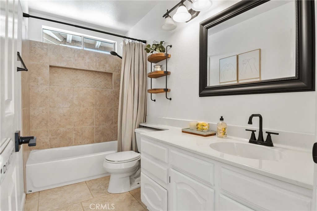 9376 Ruby Red Court Riverside, CA 92508 - Photo 32 of 54 a bathroom with a granite countertop sink a toilet and shower