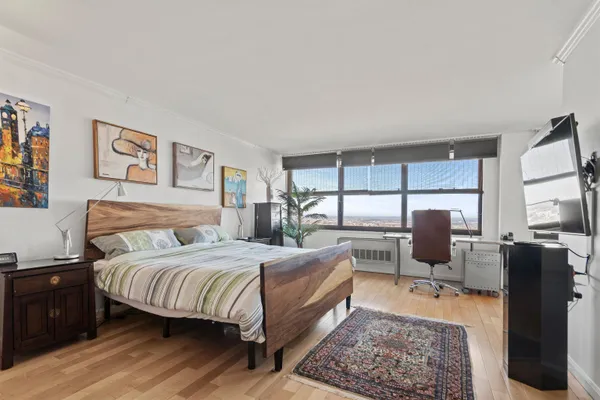 a bedroom with a bed a couch and large window