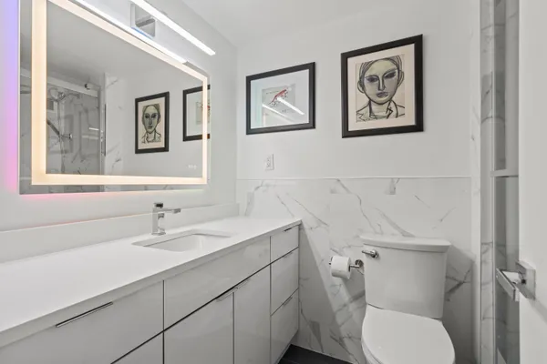 a bathroom with a toilet sink and mirror
