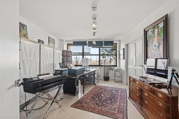 a view of a workspace with furniture and a window