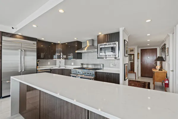 a large kitchen with stainless steel appliances and a refrigerator