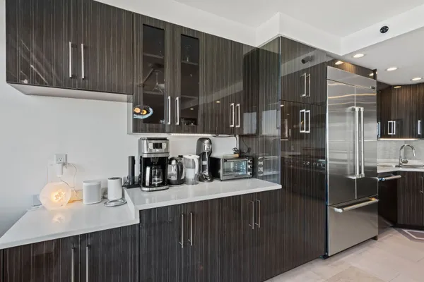a kitchen with stainless steel appliances a sink dishwasher a refrigerator and cabinets