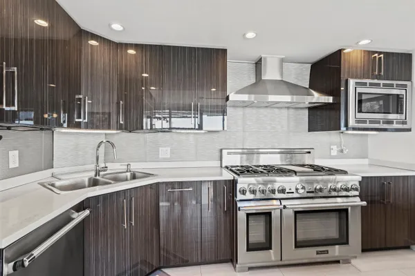 a kitchen with stainless steel appliances a sink stove and cabinets