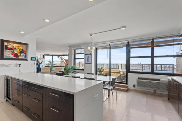 a living room with furniture large windows and flat screen tv