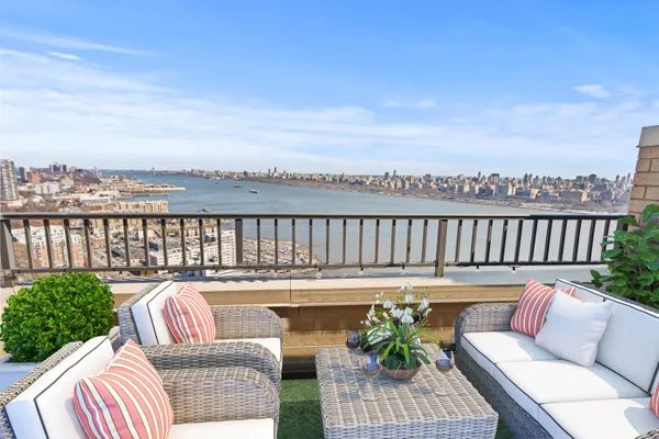 a roof deck with couches and wooden floor
