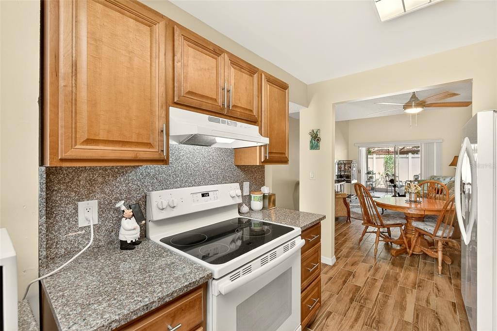2064 Sunset Point Road, Unit 73 Clearwater, FL 33765 - Photo 18 of 58 a kitchen with stainless steel appliances granite countertop a stove a sink and a microwave