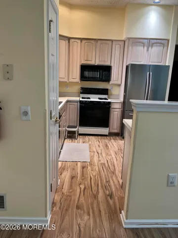 a kitchen with a refrigerator and a stove top oven