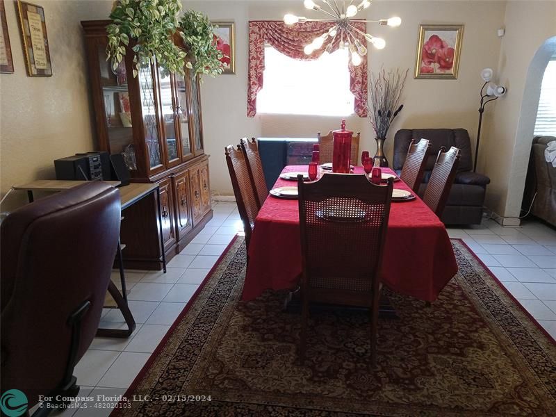 a dining room with furniture a rug and a potted plant