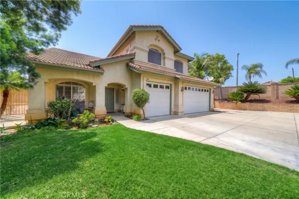 a front view of a house with a yard and potted plants