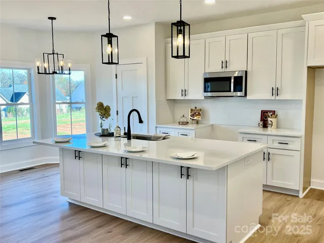 a kitchen with stainless steel appliances a sink a stove a microwave and cabinets