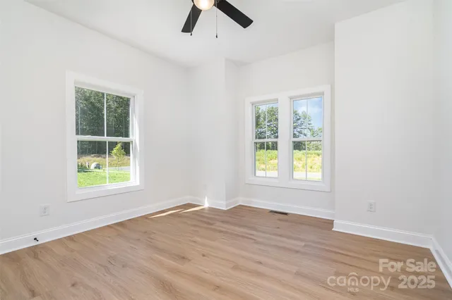 an empty room with a window and wooden floor