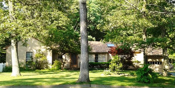 a brick house with a big yard and large trees