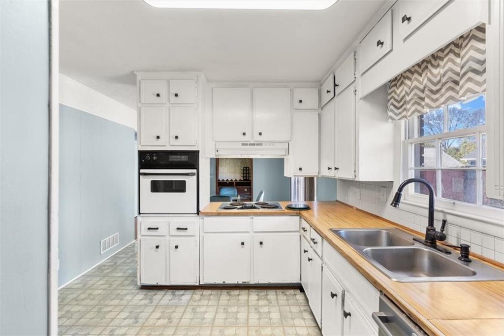 213 Cook Street Cartersville, GA 30120 - Photo 11 of 45 a kitchen with kitchen island granite countertop a sink a counter space appliances and cabinets