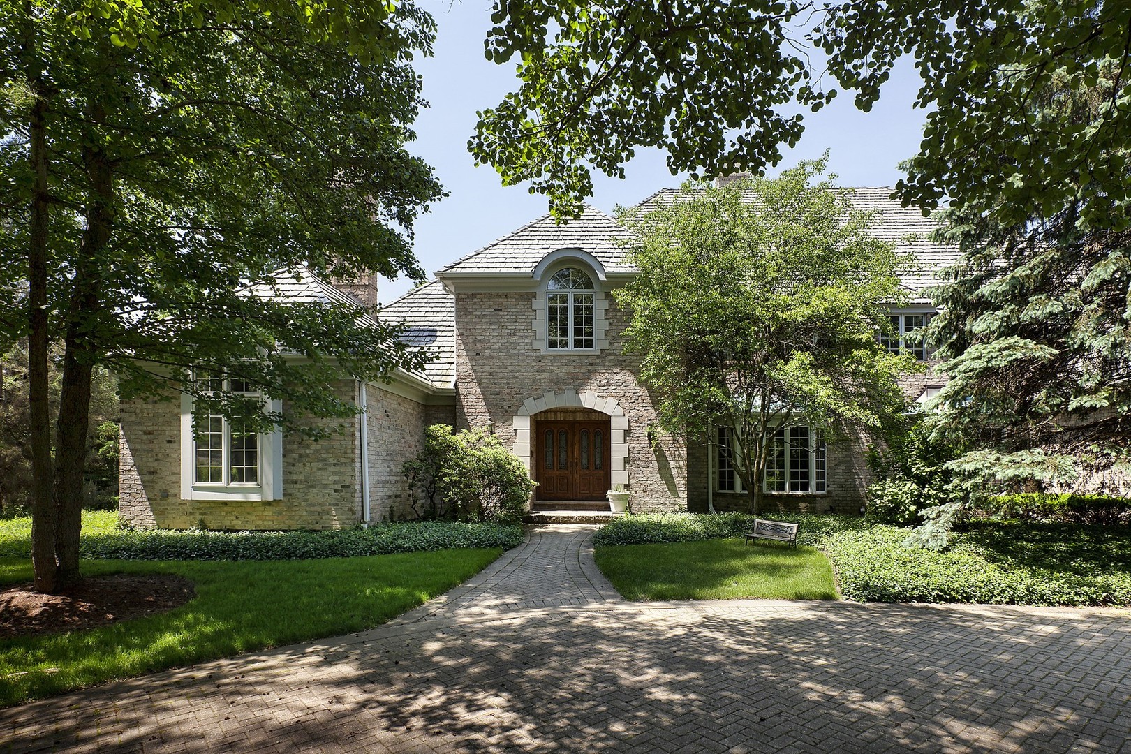 a front view of a house with a yard and tree
