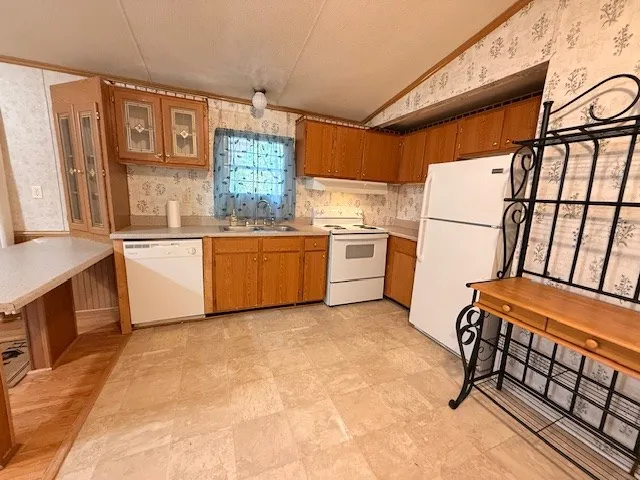 a kitchen with granite countertop a refrigerator and a stove top oven