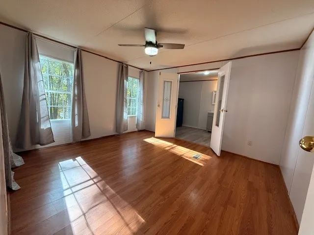 an empty room with wooden floor and windows