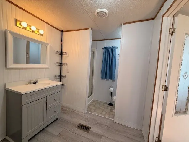 a bathroom with a sink a toilet a mirror and shower