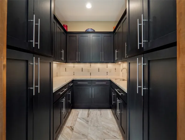 a kitchen with granite countertop a refrigerator and a sink