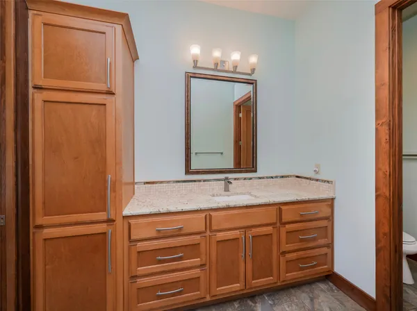 a bathroom with a granite countertop sink and a mirror