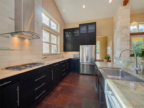 a kitchen with stainless steel appliances a sink stove and refrigerator