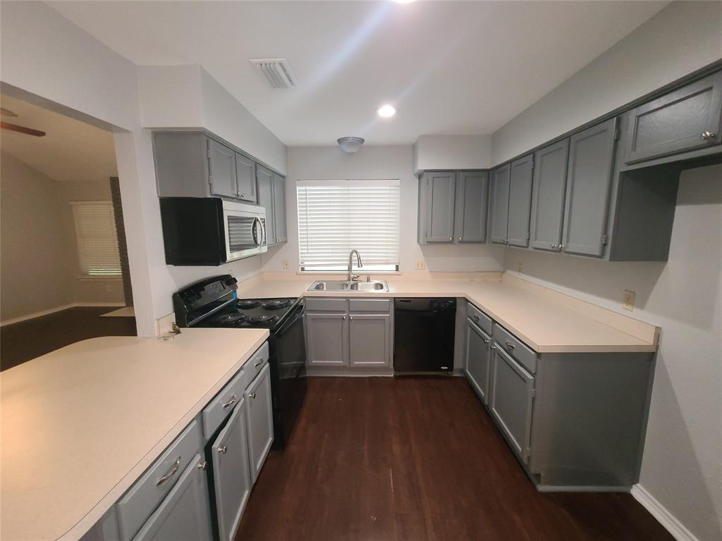 a kitchen with a sink a stove top oven a refrigerator and cabinets