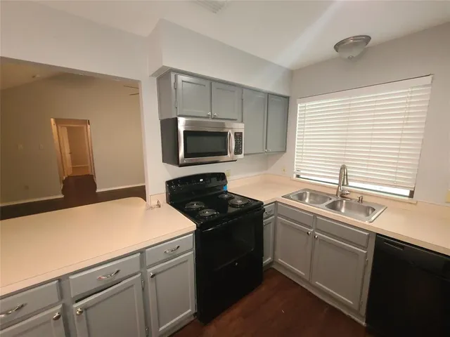a kitchen with a sink cabinets and appliances
