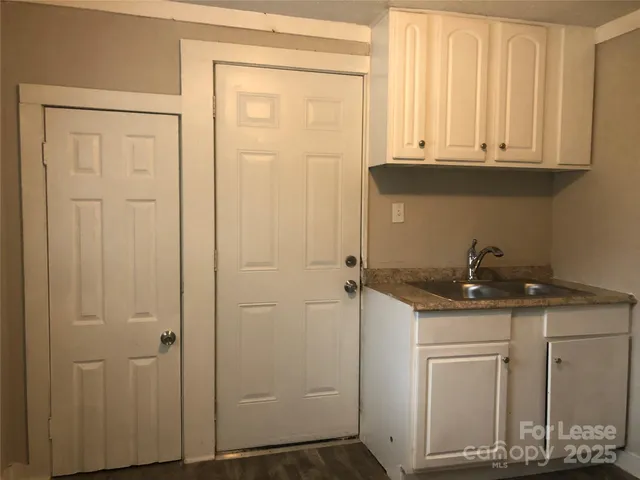 a bathroom with a granite countertop sink and cabinets