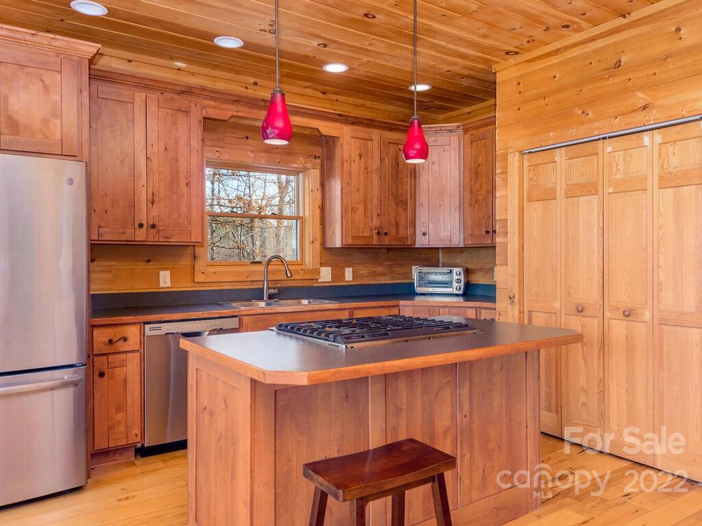 206 Legend Dr Mill Spring, Unit 8 Mill Spring, NC 28756 - Photo 21 of 47 a kitchen with a refrigerator a sink dishwasher and white cabinets with wooden floor